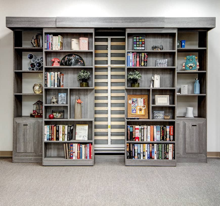 墙上的书架可以打开，将床从储藏室中释放出来。
