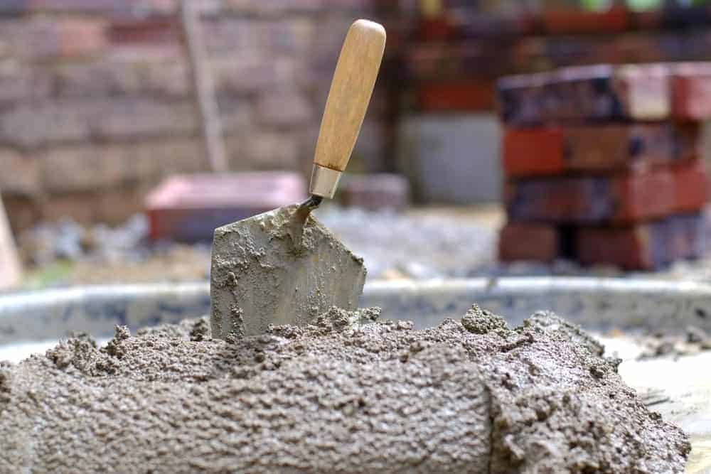 一块砖铲半埋在水泥里。