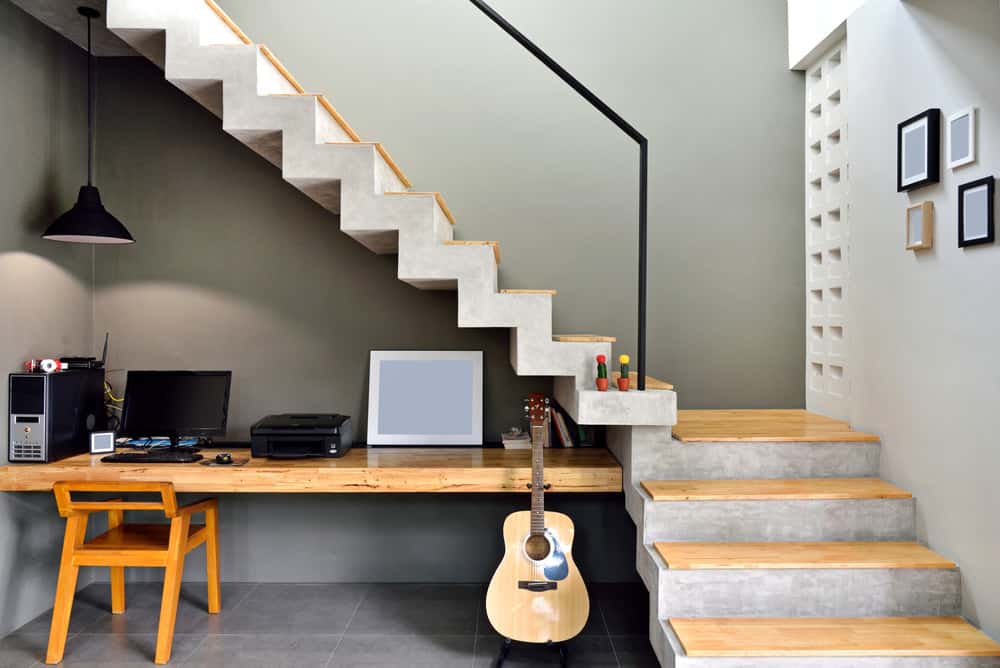华丽的木桌建在墙壁和混凝土楼梯下浮动四分之一转弯混凝土楼梯。
