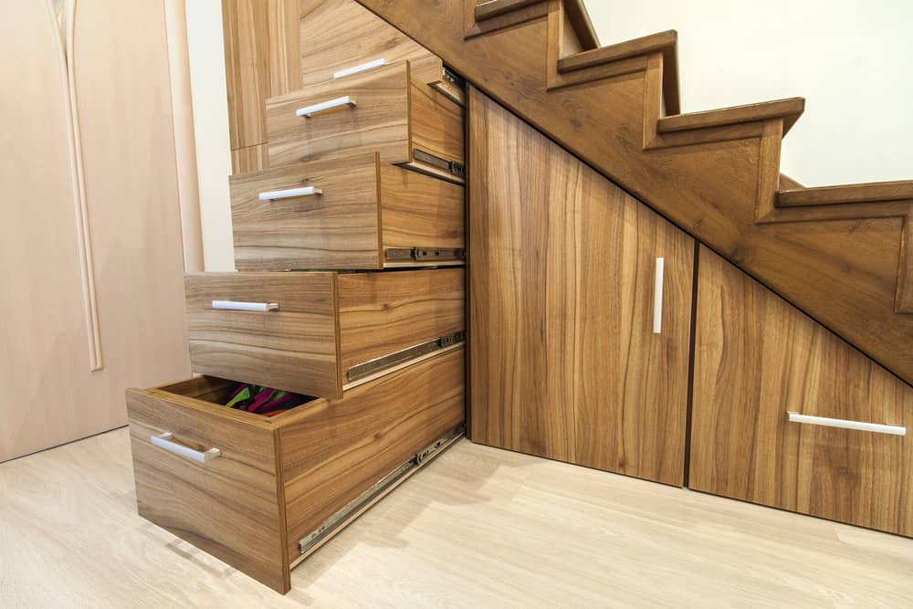 楼梯下的储藏室，包括抽屉和橱柜。精心设计，最大的存储容量和天然木材表面看起来很好。