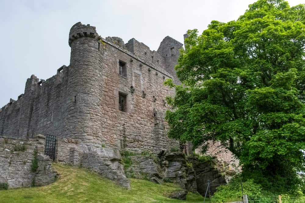 倾斜的草原上有一座石砌的铁门城堡。