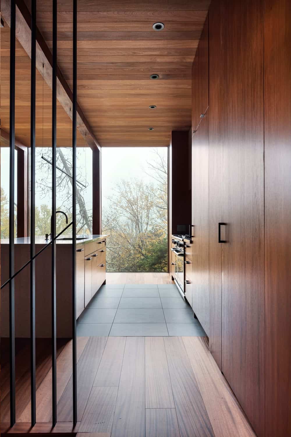 由yh2 architects设计的现代厨房，配有所有木制橱柜，地板，岛台和天花板