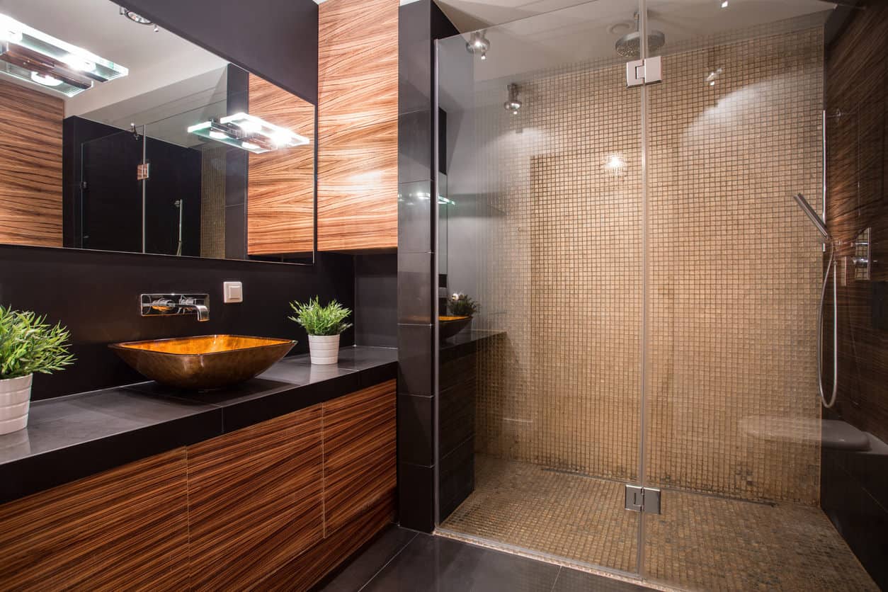 现代亚洲风格的主浴室，深色纹理的木材，方形容器盆，以及深棕色的瓷砖。