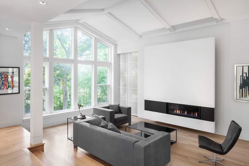 现代住宅设有一个小的正式起居区，在舒适的壁炉前设有一个时尚的灰色沙发。