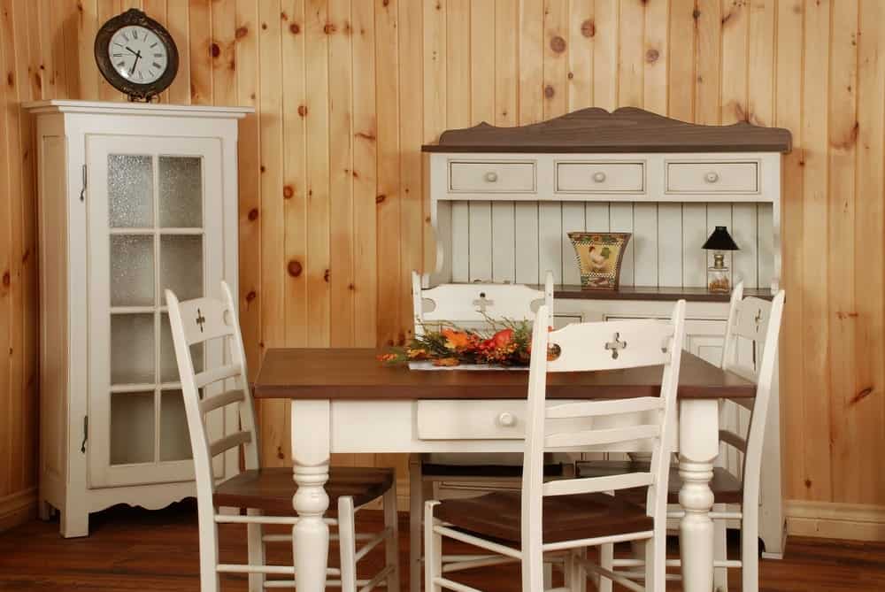 厨房里有老式的白色木制家具和配套的餐桌。
