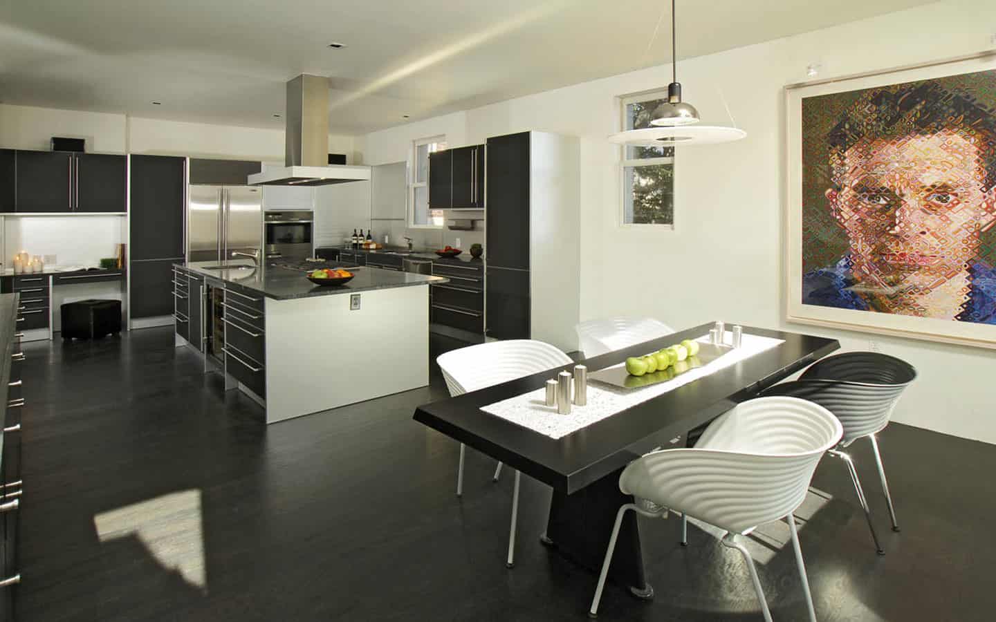 大u型黑色厨房，深色木地板和黑色厨房餐桌。