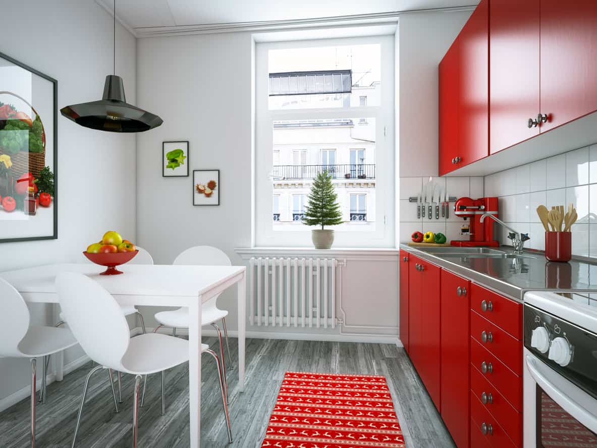可爱的公寓厨房，红色的橱柜和白色的电器。还有一张亮白色的餐桌，四把白色椅子，白色的墙壁和天花板。红白配色真的很好。