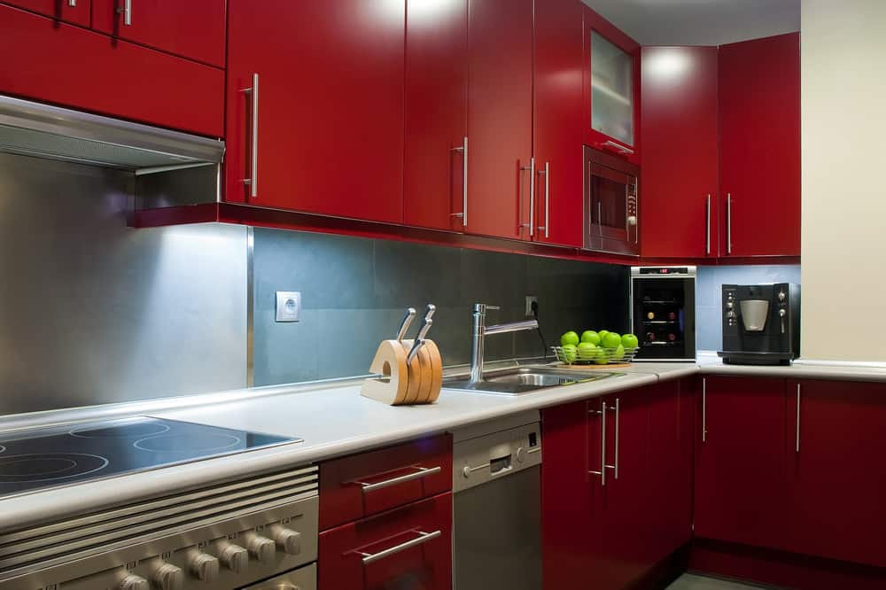 近距离的当代红色厨房铬五金和白色台面。