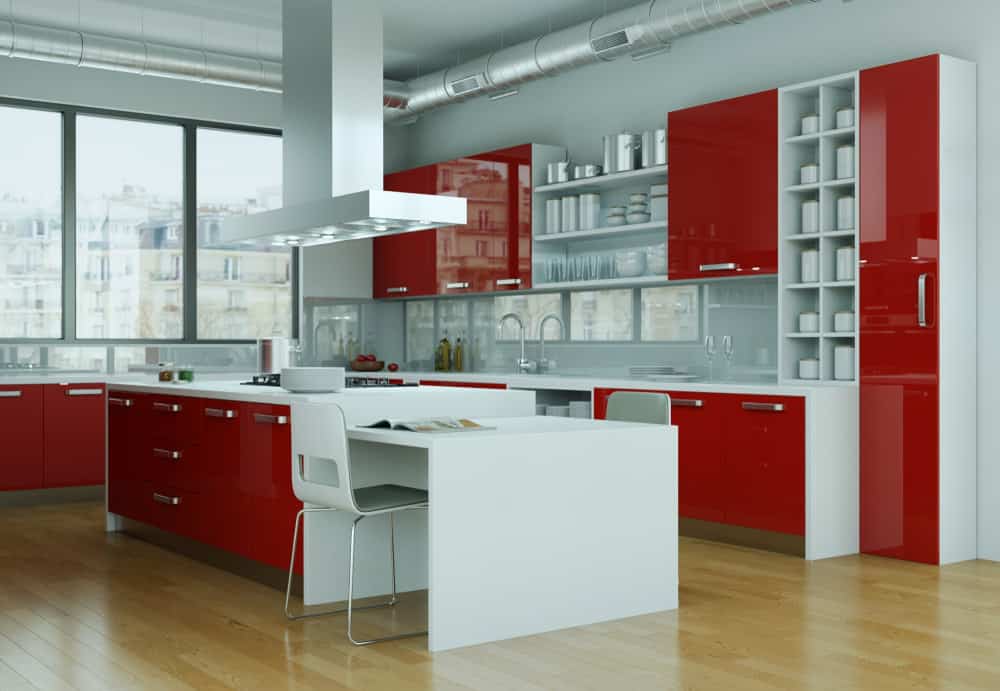 大的红色和白色阁楼厨房。注意这些柜子的正面是红色的，侧面是白色的。大面积的白色抵消了红色的亮度。我认为它做得非常好。在这个装修过的阁楼公寓里，你可以看到裸露的管道。