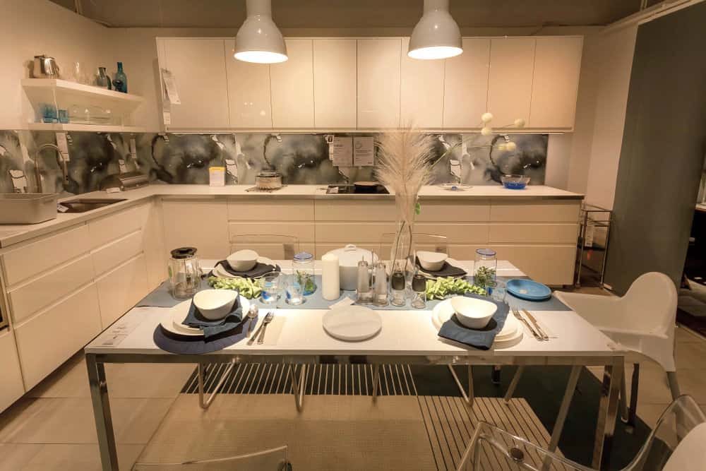 这个厨房似乎受到了东方风格的影响。餐具由漂亮的白色陶瓷汤碗和绿色皱边餐巾纸组成，仿照生菜叶子。大多数家具和固定装置都是柔和明亮的白色，但引人注目的是美丽的后挡板，其旋转的黑色、白色和灰色。总体来说，气氛非常平静安详。