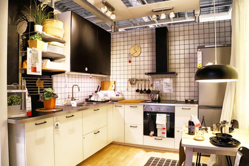 钢灰色的格子墙和天花板上挂着的黑色台灯，你可能想不到这样的厨房能散发出如此温暖的气息——但这个厨房确实如此。美丽的金色木地板，还有柳条篮子和天花板上的小射灯，让整个房间充满了温暖的金色光芒。