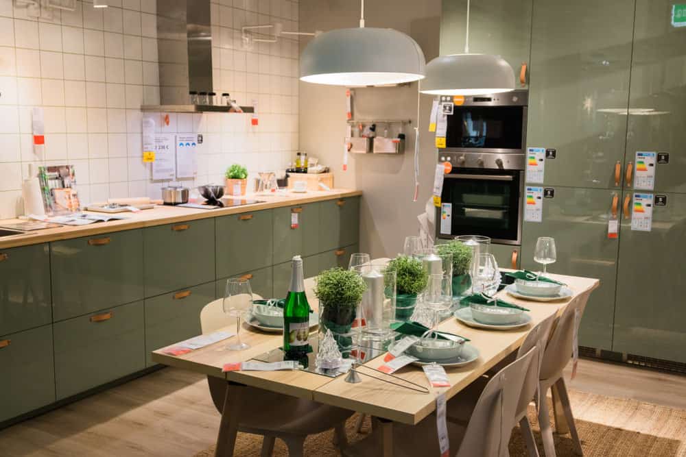 这间厨房有土黄色的木桌和薄荷绿色的固定装置，是家庭放松晚餐的完美场所。餐桌中间摆放的绿色植物，加上木制的décor，将自然融入可爱的厨房。