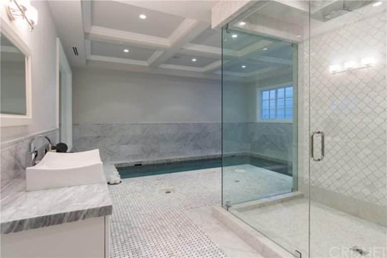 没有什么比这个室内游泳池更简单的了，它是浴室的延伸。白色的天花板，白色的瓷砖和灰色的色调，这个室内游泳池看起来简单放松和僻静。