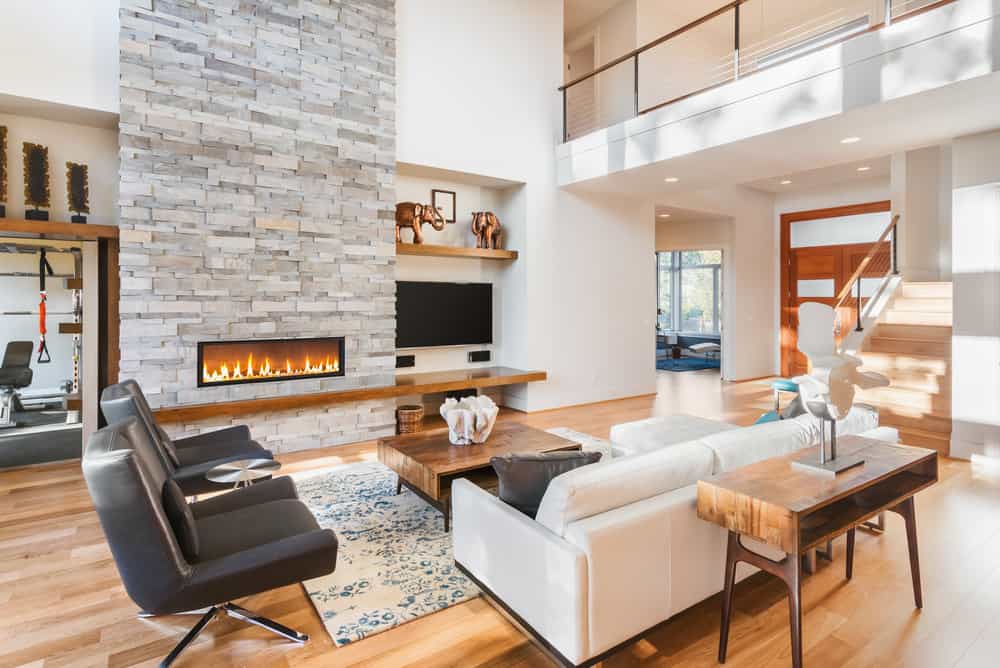 浅暖色硬木地板为这个房间增添了色彩，否则简单，冷色调的家具与一些温暖的桌子形式的口音。