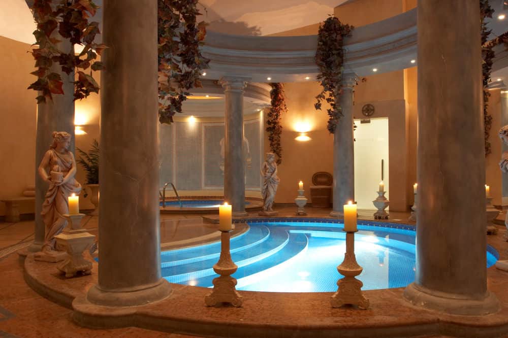 浪漫和异国情调是形容这个室内游泳池的最好方式。被点燃的蜡烛、高耸的柱子和从天花板上垂下的花朵包围着，整个空间中闪烁着柔和的金橙色灯光色调，这个游泳池是给爱人惊喜的完美选择。