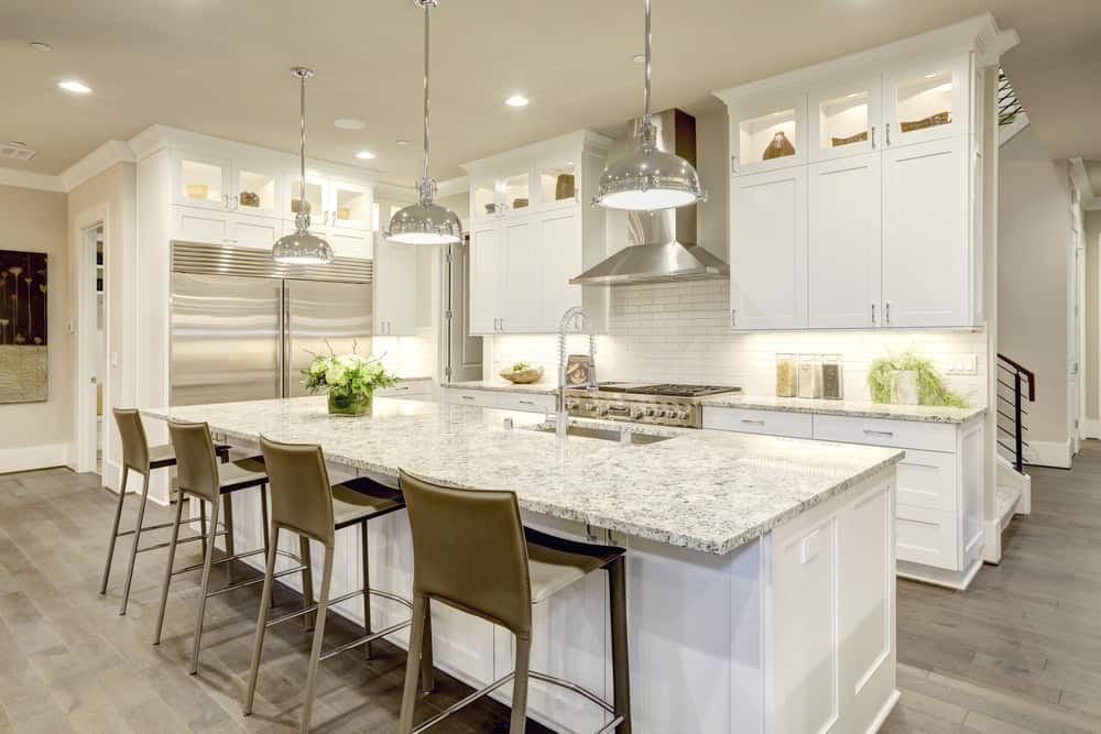 没有哪个厨房能比这个看起来更精致了。完美的白色家具被牛奶咖啡高脚椅和悬挂的灯和储藏室门上的微妙的钢铁触感所强调。其结果是一种精致的美感，会让你渴望改造你自己的厨房。