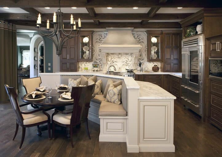 这个宏伟的厨房拥有优雅的美丽和辉煌，这是由高品质的木家具与现代配件相结合而来的。深色的木柜和木地板给厨房一种温暖舒适的感觉，而干净的白色大理石柜台和浮夸的墙壁设计在深棕色的衬托下是完美的亮点。