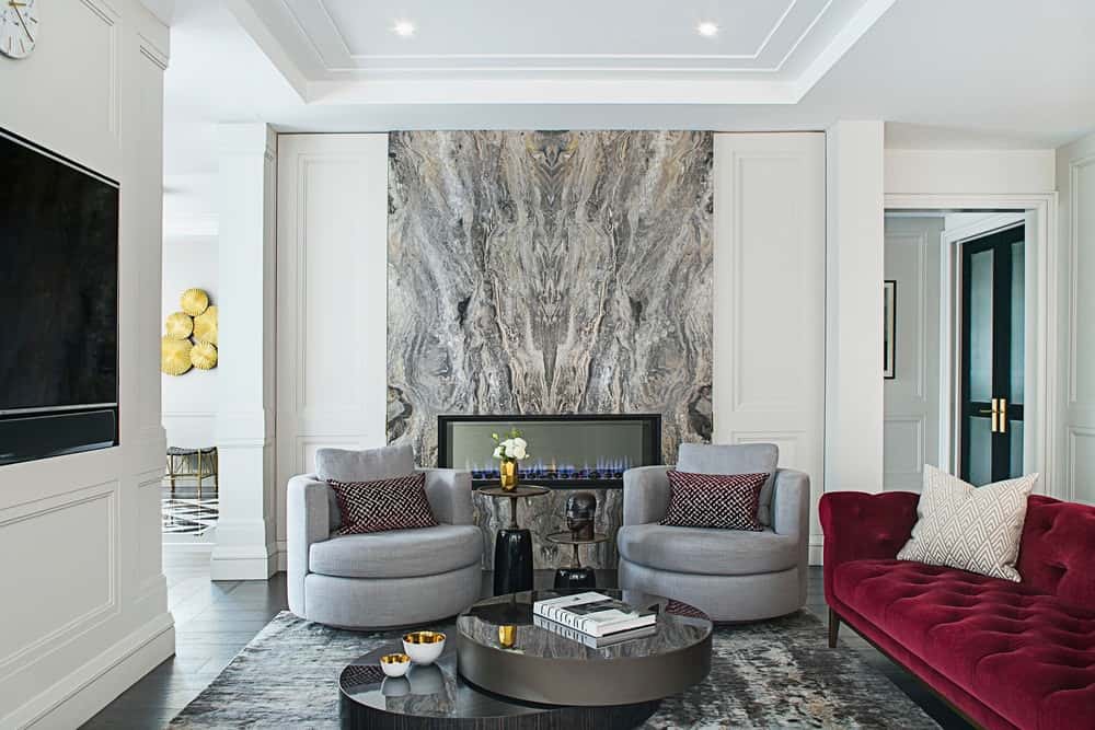 时尚的当代客厅引入古典元素，做出独特的陈述。栗色的沙发为这个有着大理石壁炉和柔和色调的房间增添了一丝色彩(以及旧世界风格的反常)，否则它就会牢牢扎根于当下。