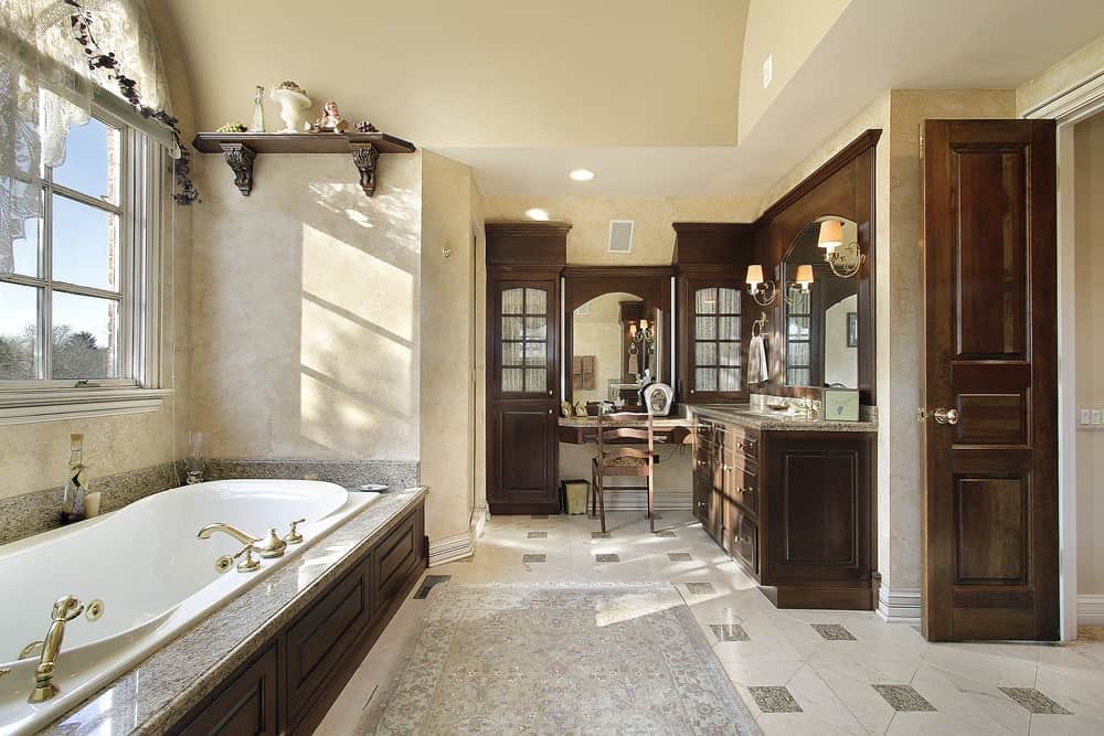 豪华的主浴室，瓷砖地板，梳妆台，和皇冠造型的落在浴缸。