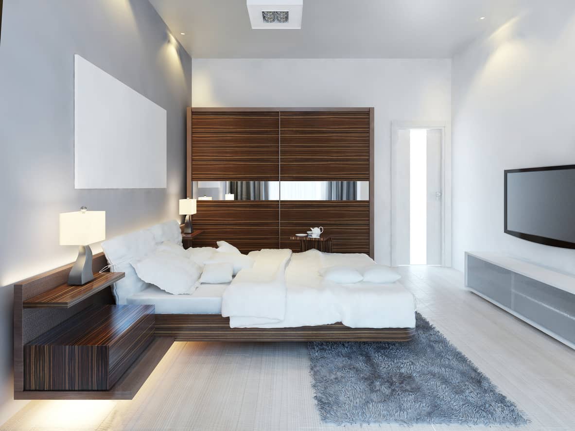 我喜欢天然木地板没有完全被床尾的小地毯掩盖。深色的木材与浅色的木地板和白色的墙壁很好地并列在一起。看看漂浮的床头柜和床下的灯光。