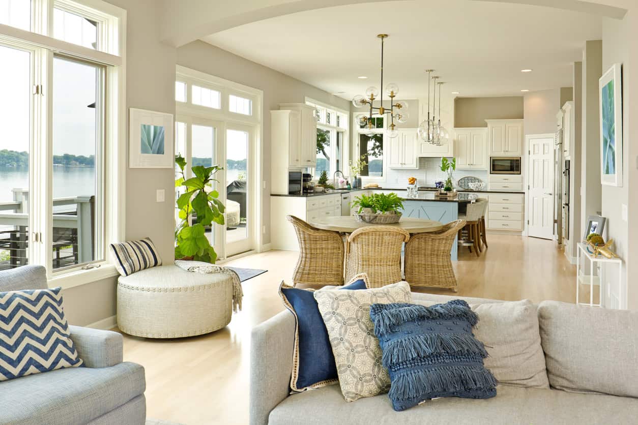 这所房子将厨房和客厅优雅地融合在一起，巧妙地放置了圆形餐桌，作为缓冲地带。更多的椅子排列在厨房岛，为家庭成员提供额外的座位。一些盆栽植物为这个地方带来了生机，并突出了在这里发挥作用的淡蓝色和象牙色的各种色调。
