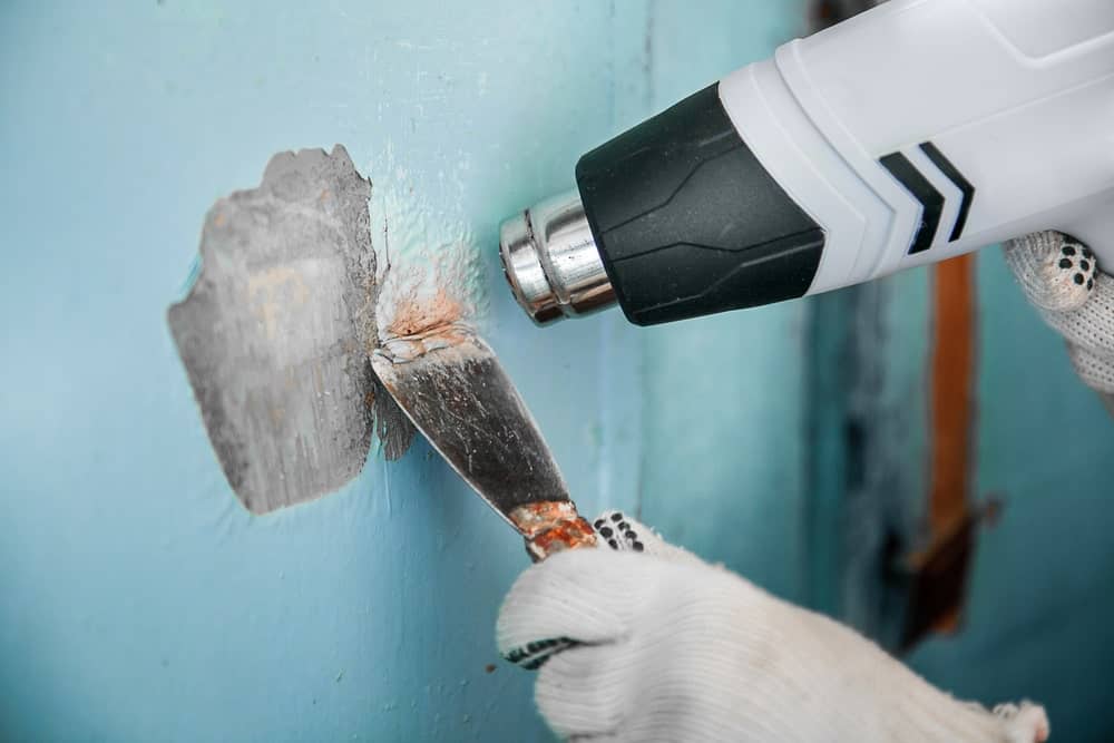 使用油漆清除工具清除墙壁上的旧油漆。