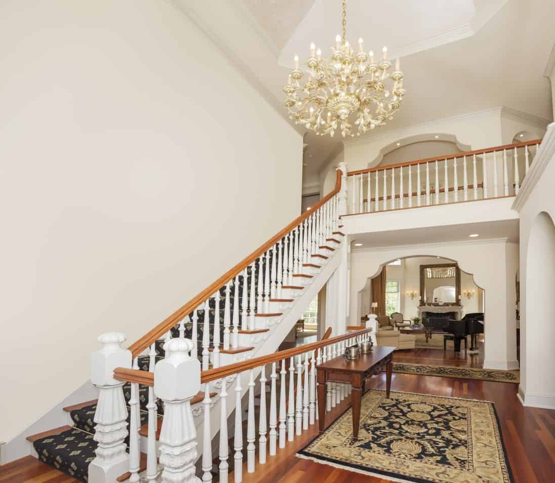 经典门厅拥有光滑的硬木地板，白色墙壁和白色楼梯栏杆。地毯是如此迷人，还有优雅的吊灯。