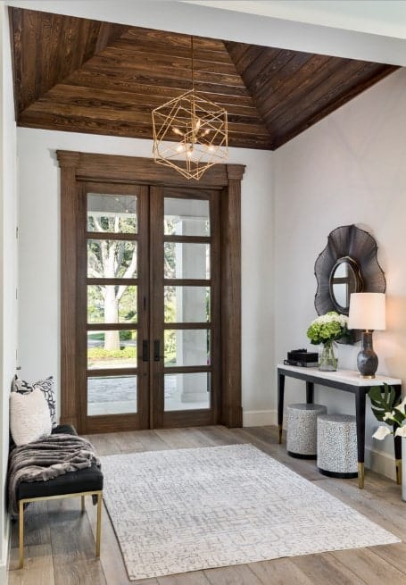 小门厅设有硬木地板，上面有地毯，白色墙壁和棕色天花板。门厅提供了一个漂亮的小吊灯作为照明。