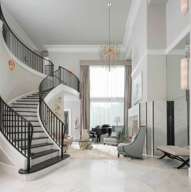 这个大门厅拥有白色大理石瓷砖地板和浅灰色的墙壁。楼梯看起来完美的家庭风格，而枝形吊灯匹配优雅的照明遍布各地。