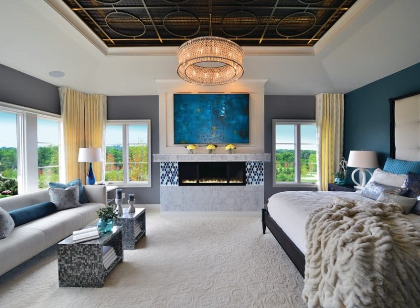 这间豪华的主卧室结合了不同深浅的蓝色和灰色，为独特的现代外观。墙壁的暖色调抵消了沙发和地毯地板上的冷色调。不同深浅的蓝色也可以用来创造一个忧郁或清新的外观。