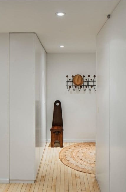 这个简单而时尚的入口以白墙和硬木地板为特色，彼此看起来很好。