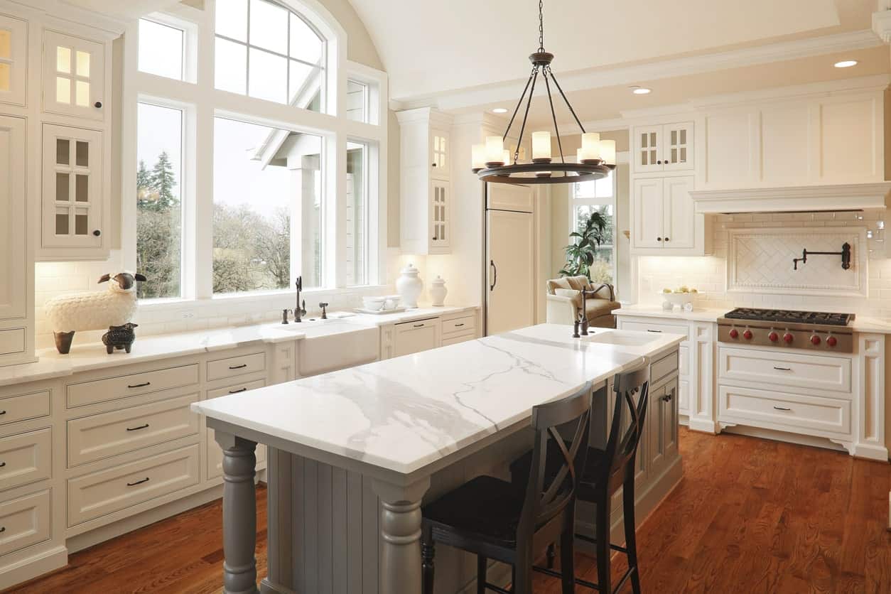 这间厨房除了地板和狭窄的中央岛台外，其他细节都是全白色的。光滑的大理石柜台真漂亮。