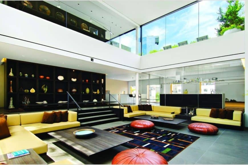 这是宽敞的起居室和一个高高的天花板,玻璃墙多彩的家具对比黑色元素。图片由Toptenrealestatedeals.com。