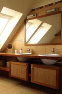 大的遮阳篷窗户为主浴室带来了充足的自然光线，主浴室设有两个位于浮动梳妆台上的容器水槽。这个空间还包括一个浸泡式浴缸，梳妆台上方的壁挂式灯具和瓷砖地板。