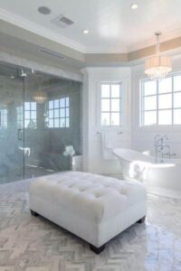 大型主浴室设有一个独立的双拖鞋浴缸，两端倾斜，底座设置在瓷砖地板上。这间房间还设有一间步入式淋浴间，一盏水晶枝形吊灯悬挂在托盘天花板上，浴缸后面还有一组窗户。
