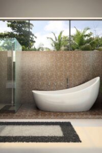 现代化的主浴室设有步入式淋浴，带有马赛克瓷砖上的独立拖鞋浴缸。这个空间还包括瓷砖地板、一块小地毯和一扇大窗户，可以让充足的自然光进入室内。