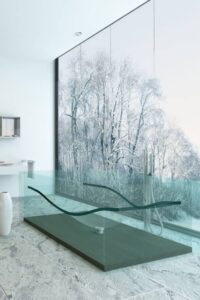 当代风格的主浴室以瓷砖地板为特色，带有容器水槽的浮动梳妆台和透明的独立浴缸，框架内设计了符合人体工程学的身体模具。透明的浴缸通常由树脂或玻璃制成，比如安东尼奥·卢皮(Antonio Lupi)的AL工作室设计的Reflex，它是用意大利公司开发的彩色树脂Cristalmood手工倒进模具的。