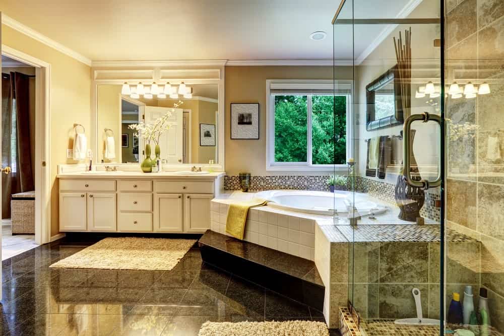 宽敞优雅的主浴室，有时尚的瓷砖地板和迷人的照明。浴缸看起来很有档次，淋浴间看起来也很不错。