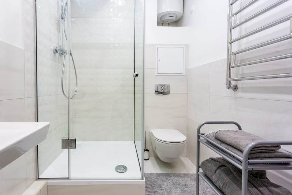 这间主浴室设有一间角落淋浴间。它还以瓷砖地板和墙壁为特色。