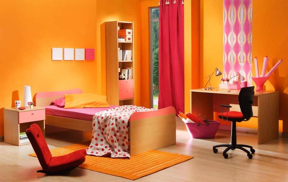 这个女孩的卧室看起来既时髦又迷人。这张床很吸引人。还有一张书桌，放在硬木地板上。