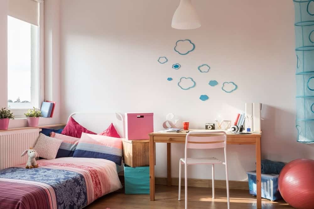 小女孩的卧室，白色的墙和蓝色的设计。这床看起来很舒服。