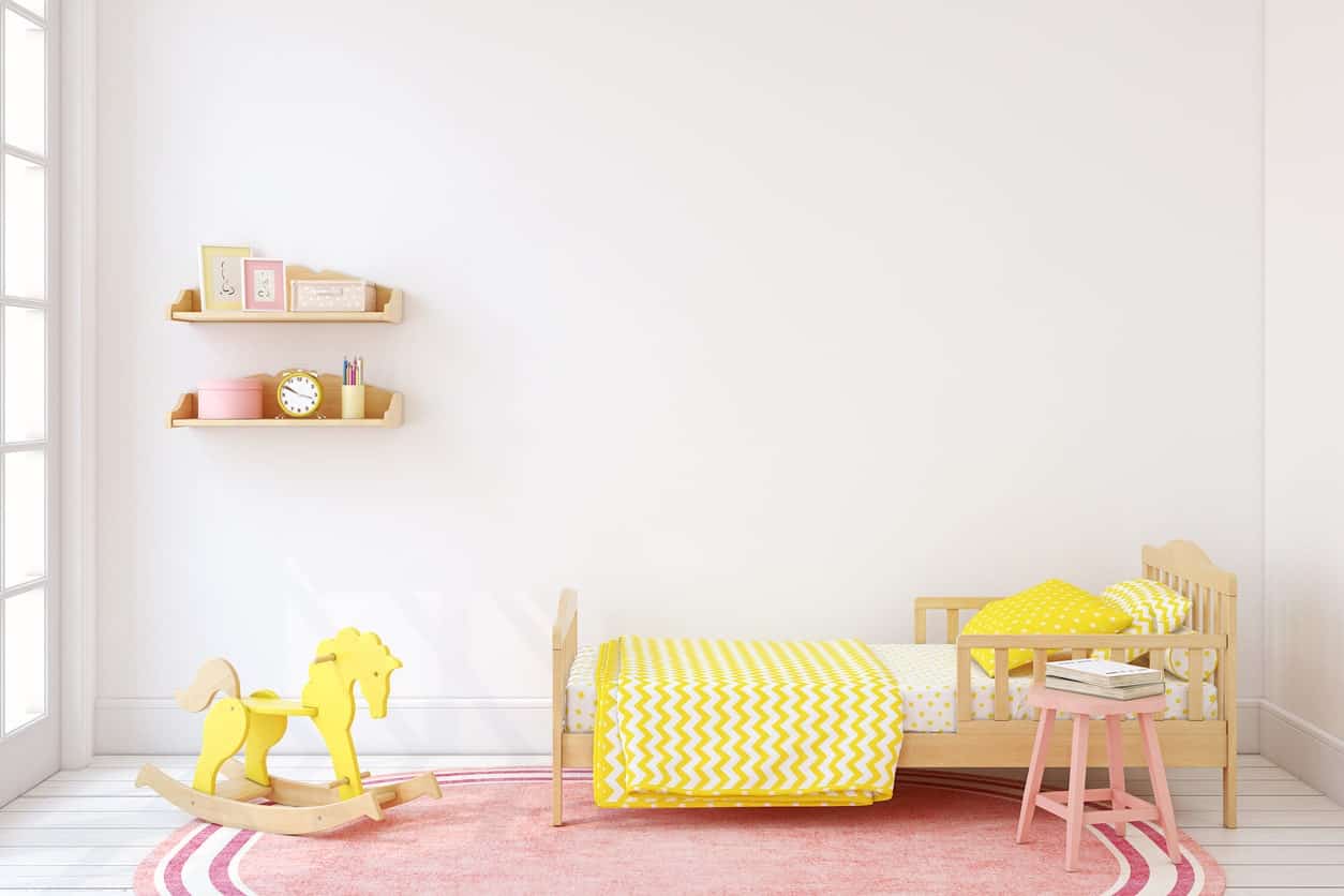 小女孩的卧室，白色的墙壁和地板，粉红色的地毯和黄色的额外口音。