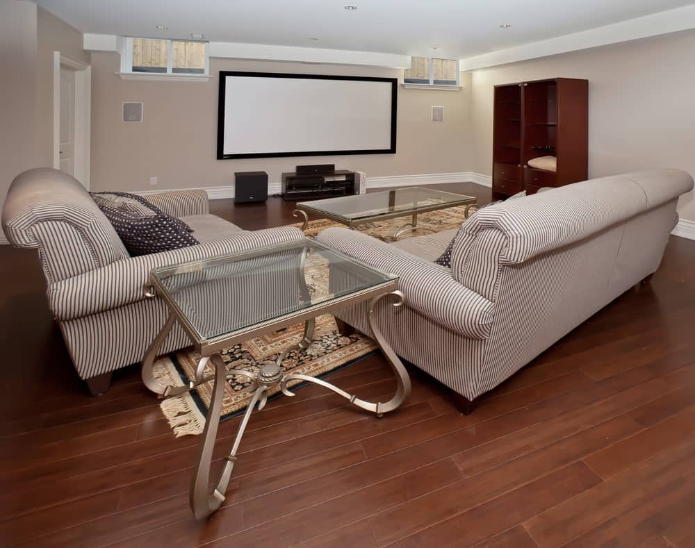 大型家庭影院设有舒适的沙发设置在硬木地板上。