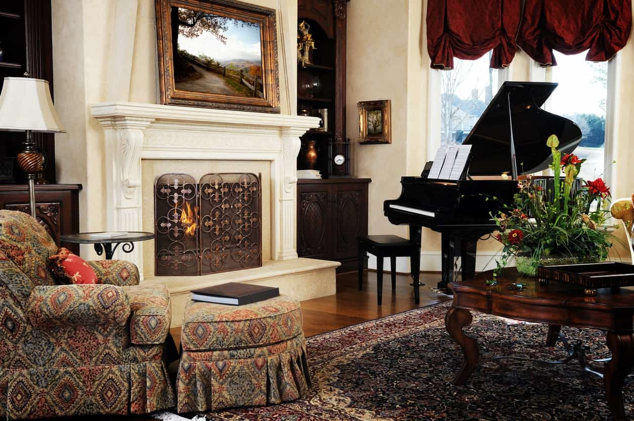 这个正式的客厅散发着优雅的气息，它的座位和壁炉，还有地毯和黑色钢琴，看起来非常漂亮。