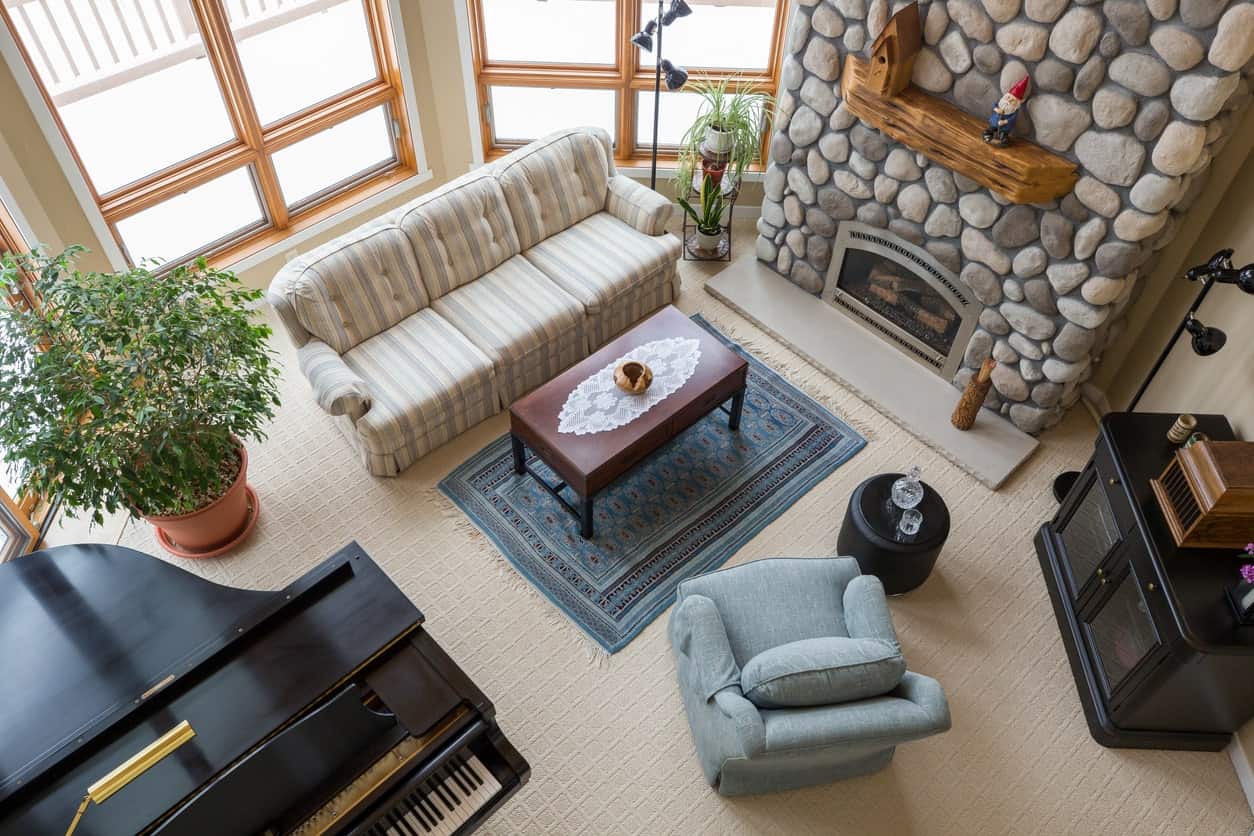 一个优雅的正式客厅，设有一组舒适的座椅和一架大钢琴放在地毯地板上。壁炉看起来很吸引人。
