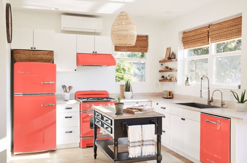 这个北欧国家的厨房的突出的pomegranate-colored元素的冰箱,烤箱和洗碗机的炉子,策略性地放置在房间里。他们给一个多彩的与白墙和内置橱柜和抽屉。