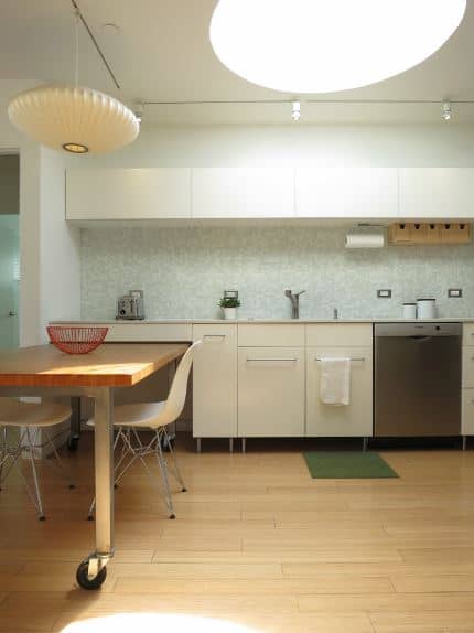 白色的天花板是由一个大圆形天窗,照亮硬木地板。木制的地板匹配表,连着厨房的半岛。朝鲜半岛有白色内置橱柜的房子洗碗机。