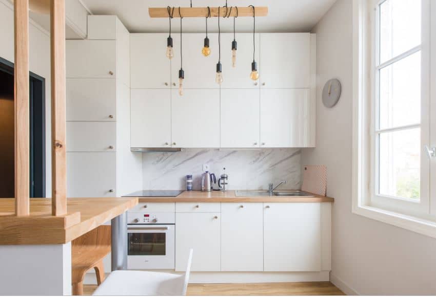 大量白色木质结构主宰这个北欧国家的厨房的墙壁内置扩展到小厨房的橱柜半岛住房一个小烤箱和下沉。这些都是明亮的大窗户让自然光线。
