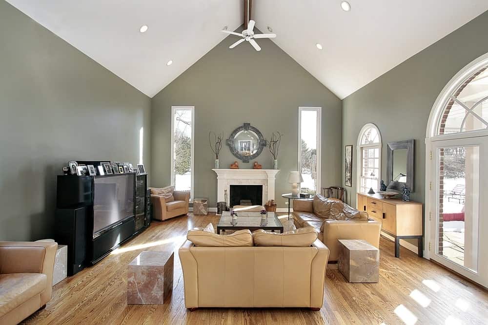 一个简单正式的客厅，米色沙发放在硬木地板上。壁炉与白色拱形天花板的搭配非常完美。