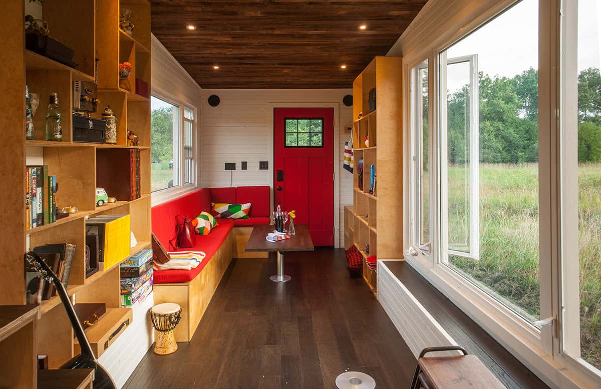 长长的小房子客厅，红色长内置l型组合沙发，咖啡桌和书架